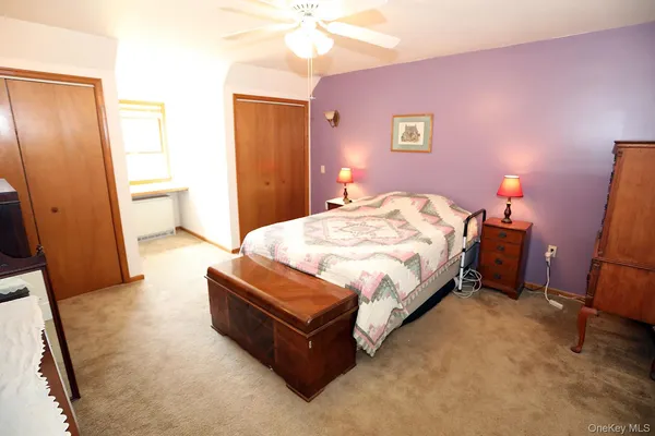 a spacious bedroom with a bed and a flat screen tv
