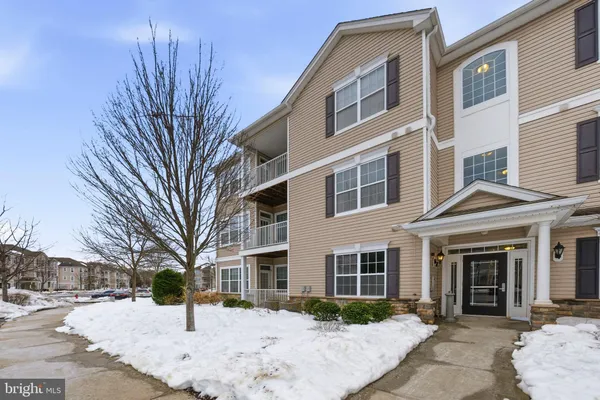 a front view of a building with a yard covered in snow