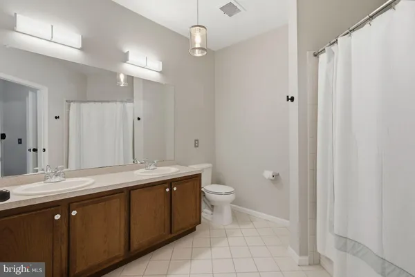 a spacious bathroom with a granite countertop sink a toilet and a mirror