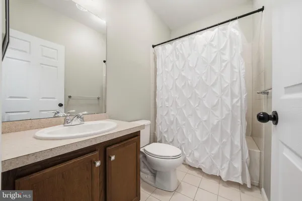 a bathroom with a sink a toilet and shower curtain