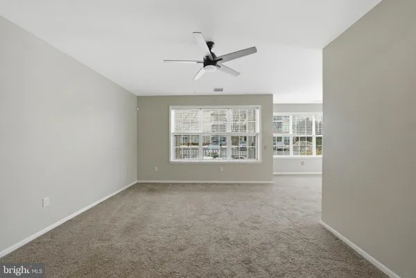 an empty room with a window and a ceiling fan