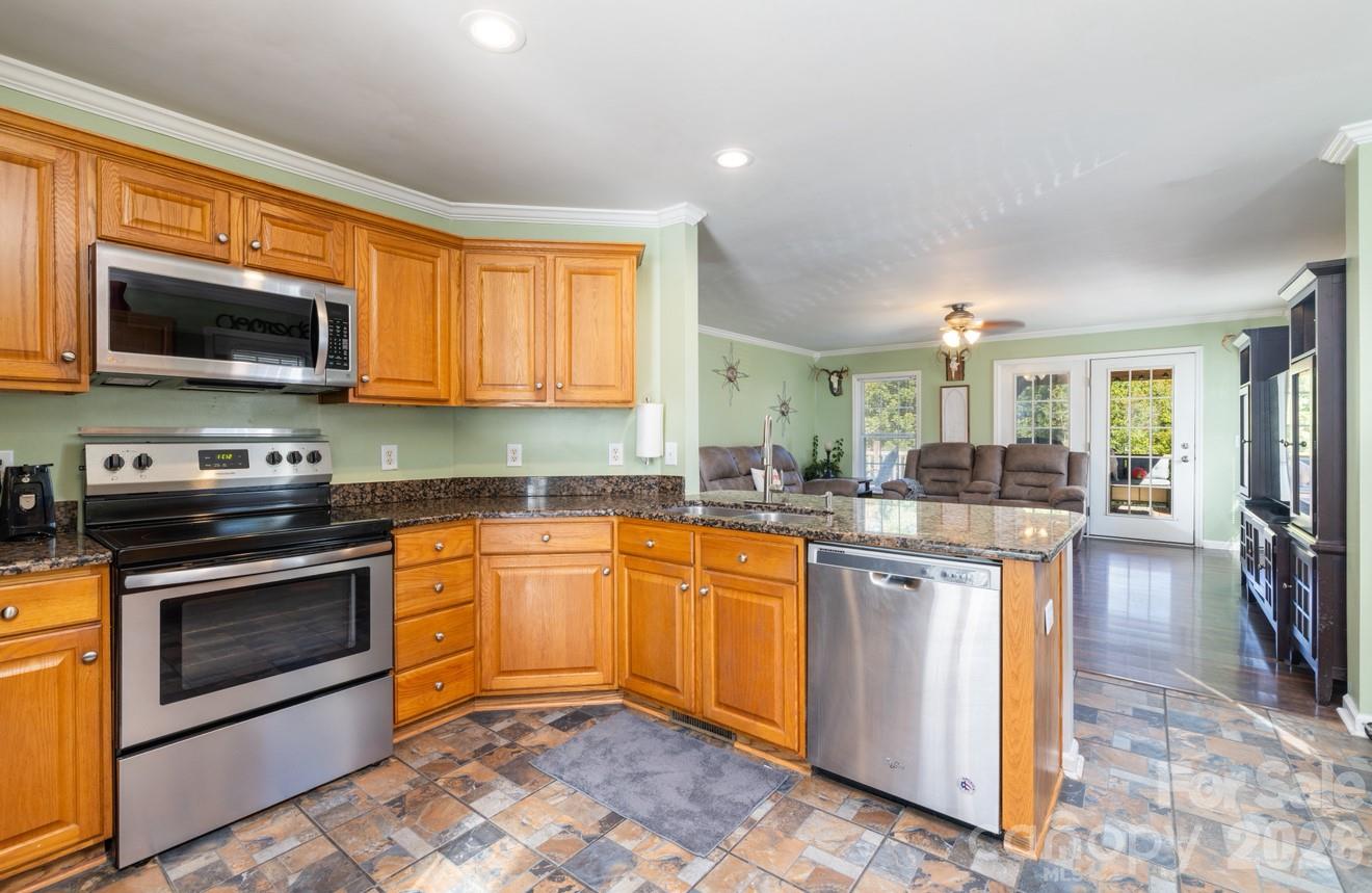 638 Acorn Acres Road Norwood, NC 28128 - Photo 3 of 23 a kitchen with stainless steel appliances granite countertop a stove top oven a sink dishwasher and a microwave oven with cabinets