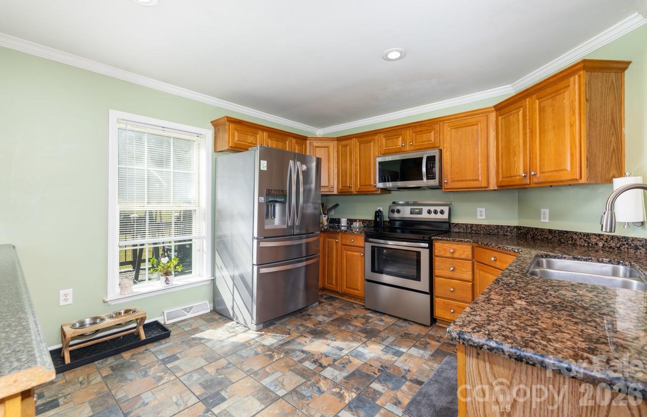 638 Acorn Acres Road Norwood, NC 28128 - Photo 5 of 23 a kitchen with granite countertop a refrigerator and a stove top oven