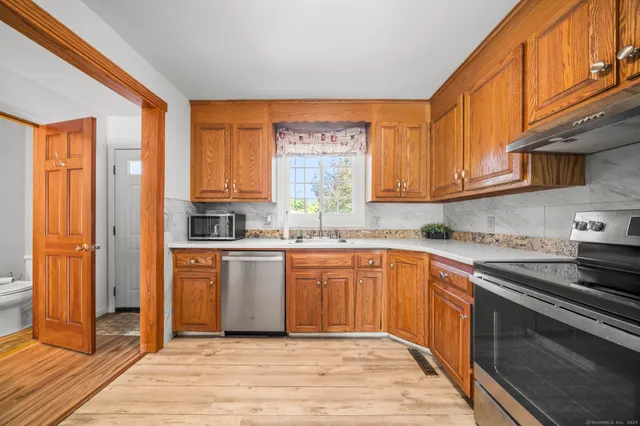 a kitchen with stainless steel appliances granite countertop a stove a sink and a refrigerator