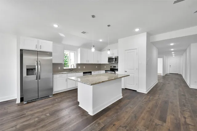 a kitchen with white cabinets and stainless steel appliances