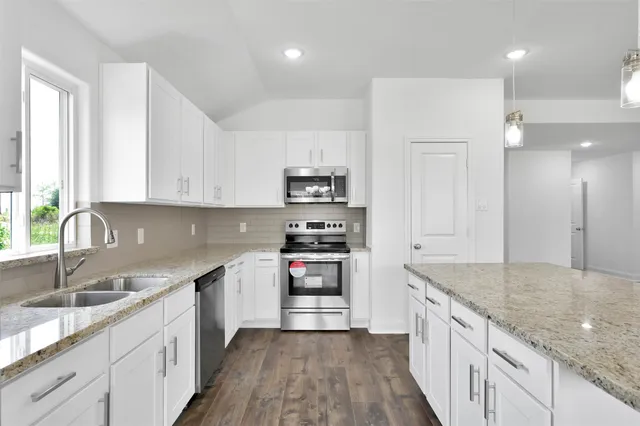a kitchen with stainless steel appliances granite countertop a sink stove and refrigerator