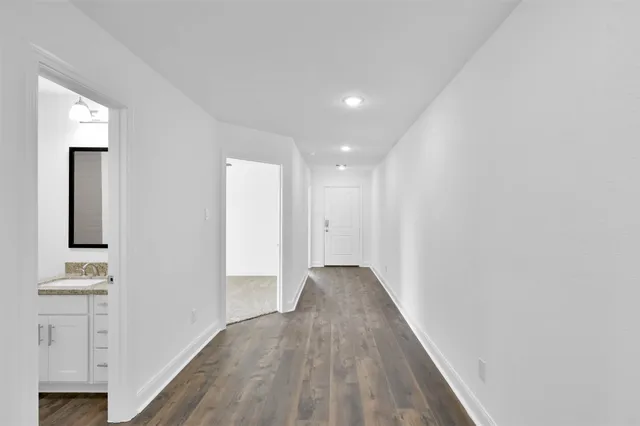 a view of a hallway with wooden floor and closet