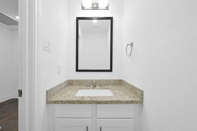 a bathroom with a granite countertop sink and mirror