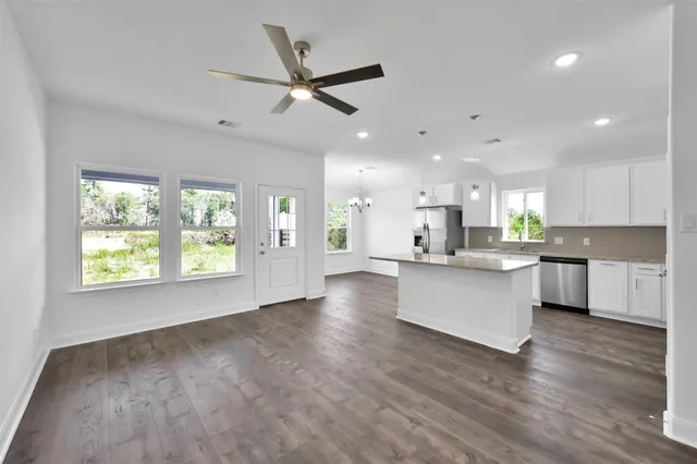 a view of kitchen with kitchen island wooden floors wooden floor and appliances