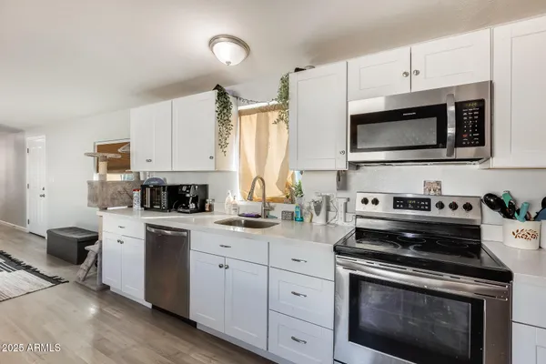 a kitchen with stainless steel appliances a stove sink microwave and cabinets