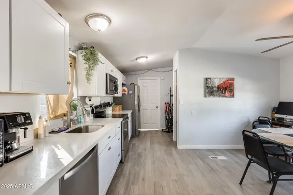 a kitchen with cabinets stainless steel appliances and a sink