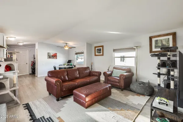 a kitchen with a sink a stove a microwave a refrigerator a white cabinets and wooden floor