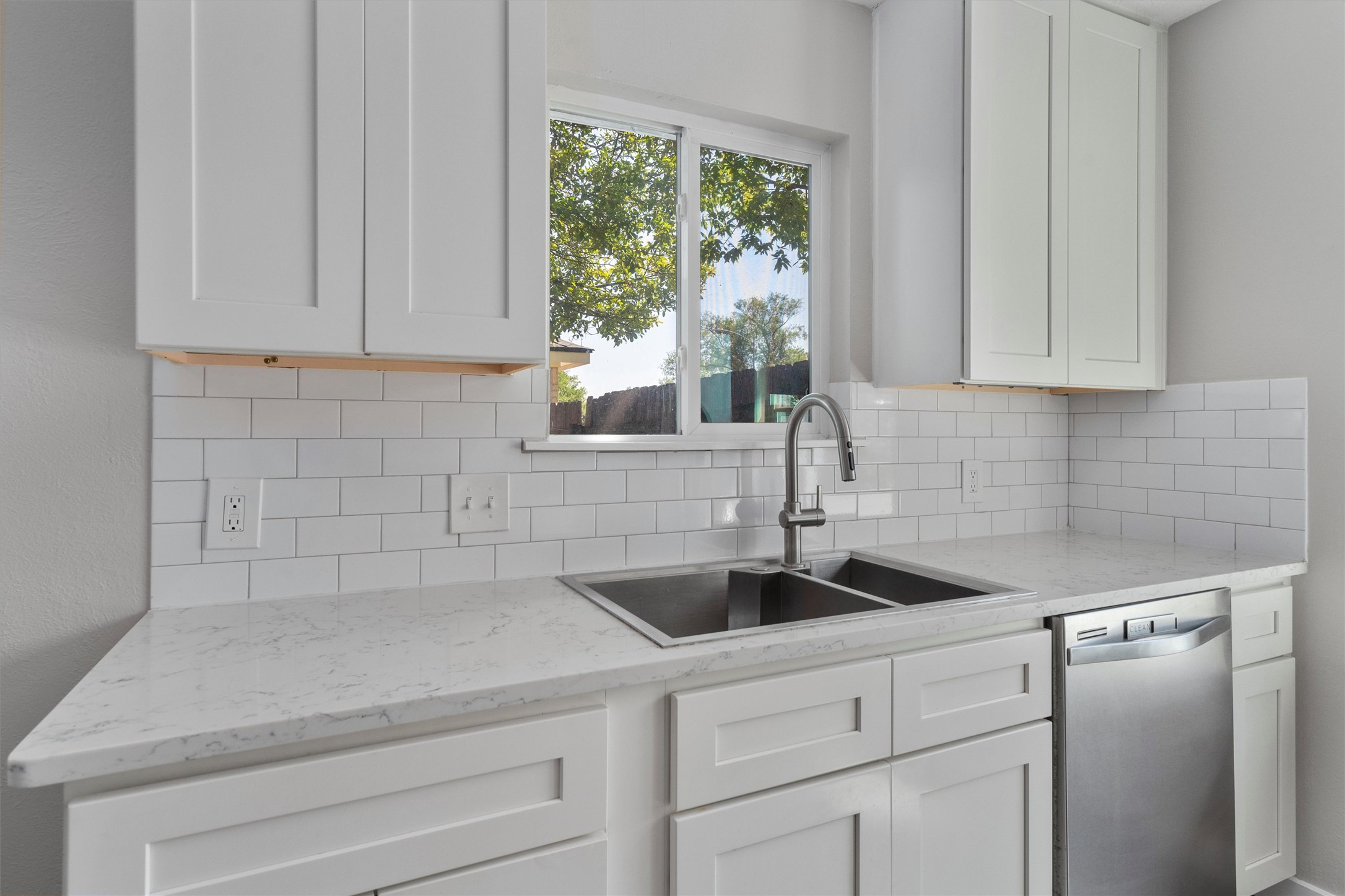 12321 Emery Oaks Road Austin, TX 78758 - Photo 10 of 27 A well-lit kitchen with classic white subway tile backsplash and ample countertop space.