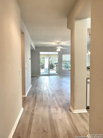 a view of a big room with wooden floor and windows