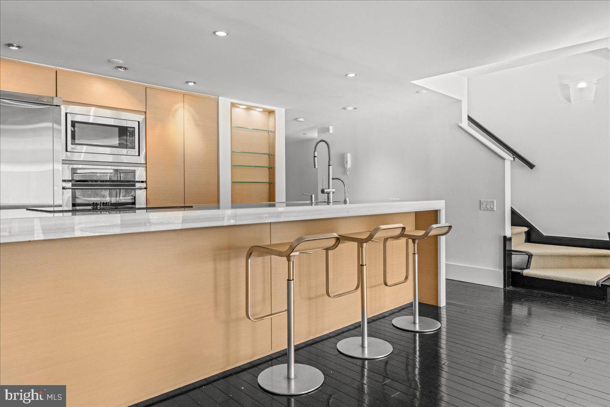350 River Road, Unit D10 New Hope, PA 18938 - Photo 9 of 41 a kitchen with stainless steel appliances granite countertop a sink a stove and a wooden floors