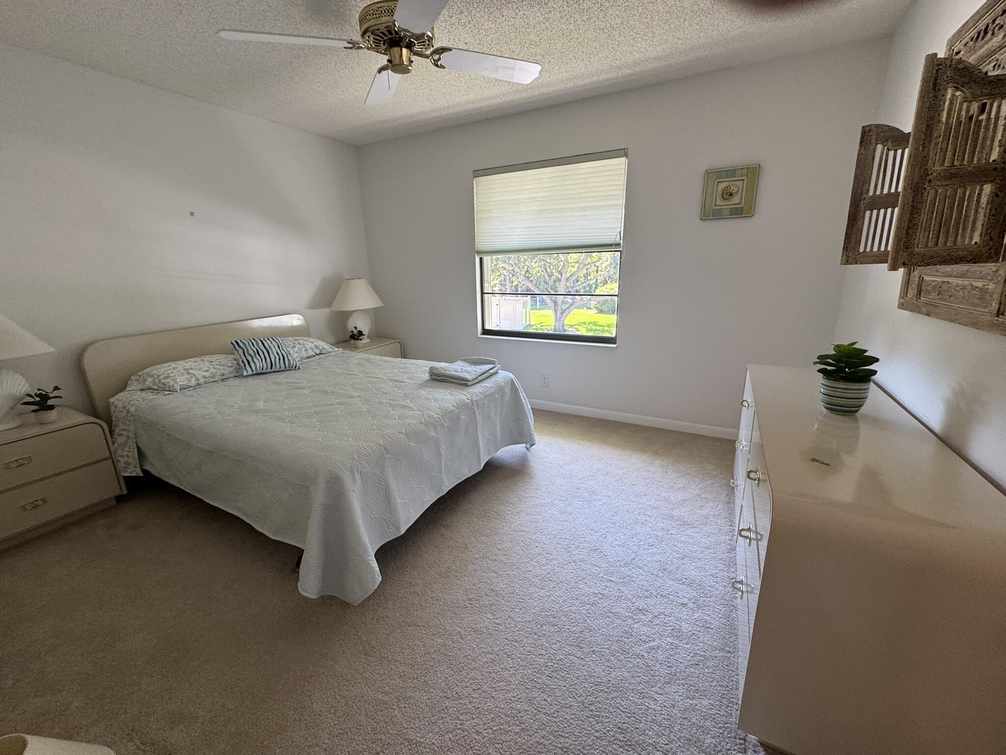 801 Sabal Ridge Circle, Unit H Palm Beach Gardens, FL 33418 - Photo 17 of 42 a bedroom with a bed and dresser
