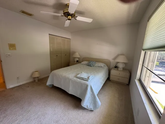 a bedroom with a bed and a large window
