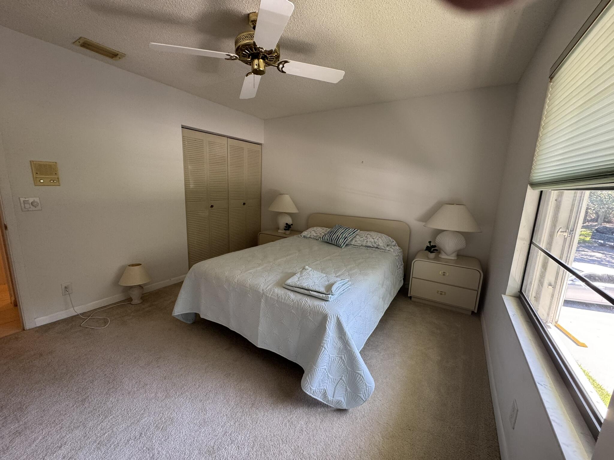 801 Sabal Ridge Circle, Unit H Palm Beach Gardens, FL 33418 - Photo 18 of 42 a bedroom with a bed and a large window