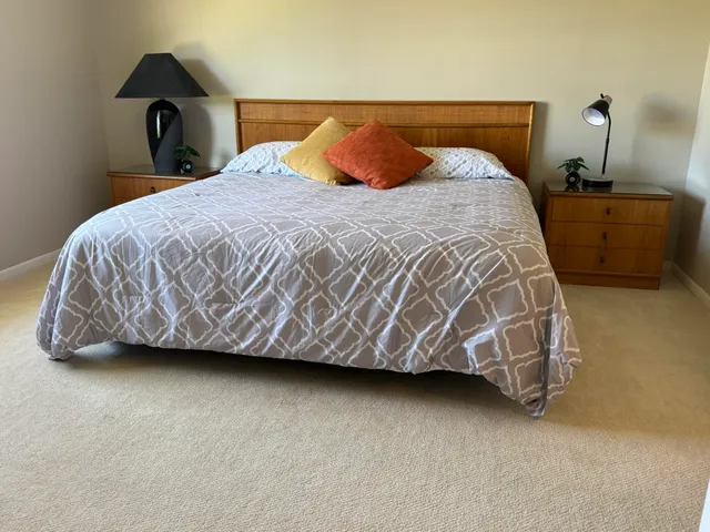 a bed sitting in a bedroom next to a lamp