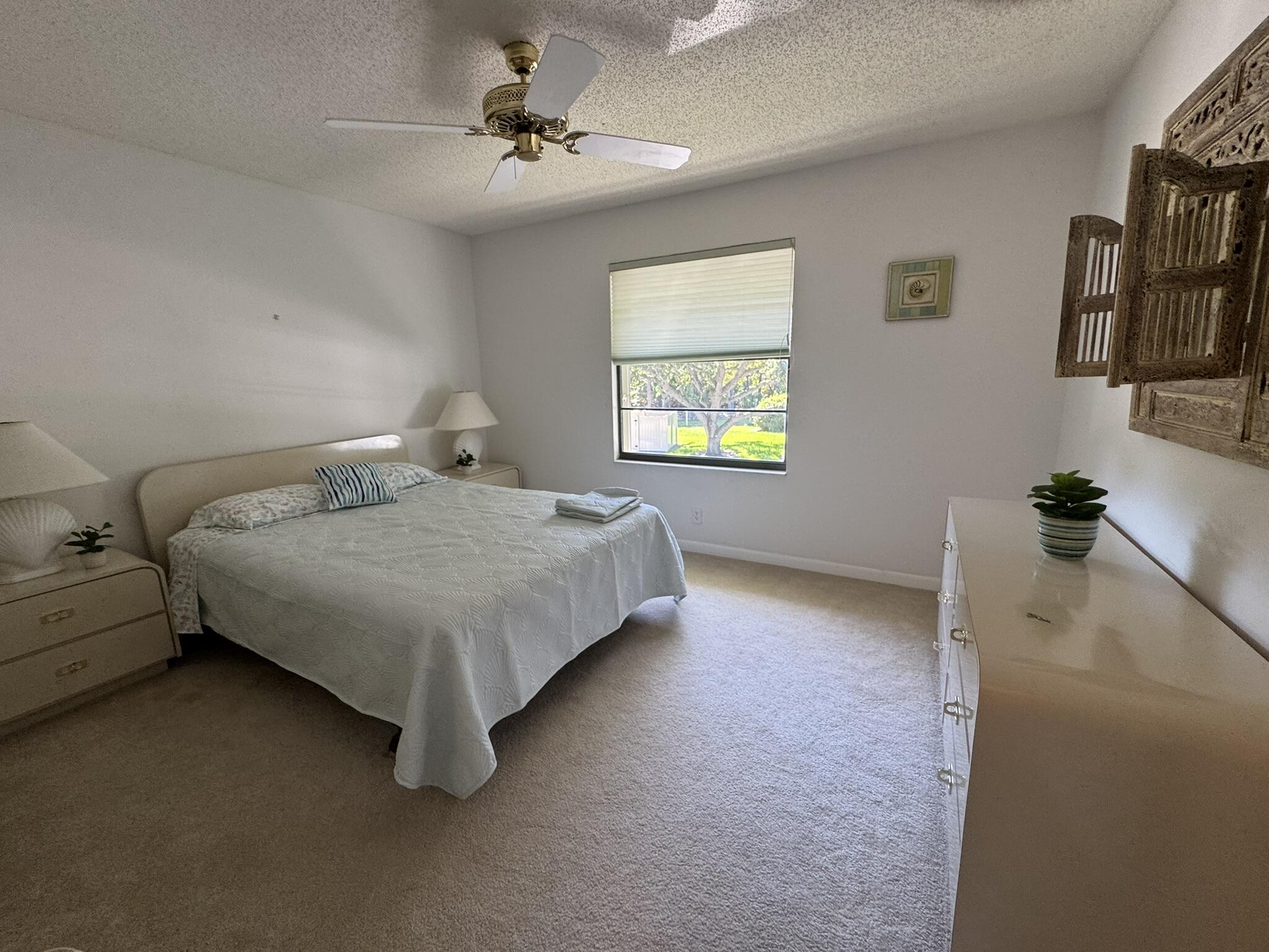 801 Sabal Ridge Circle, Unit H Palm Beach Gardens, FL 33418 - Photo 22 of 42 a bedroom with a bed dresser and a window