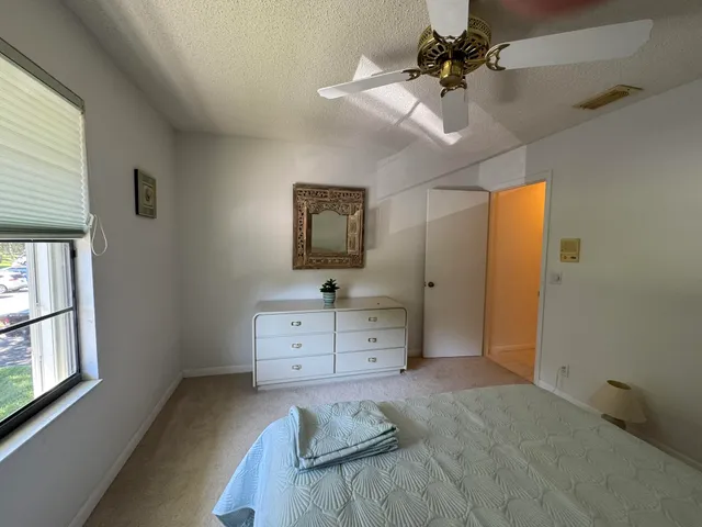 a bedroom with a bed chandelier and a window