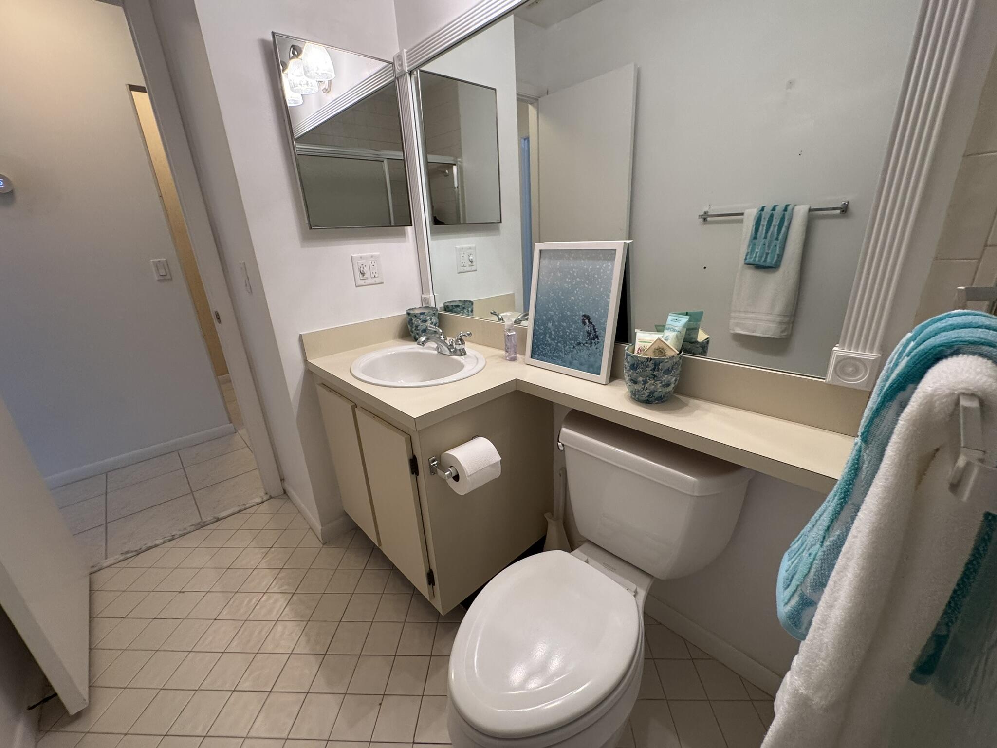 801 Sabal Ridge Circle, Unit H Palm Beach Gardens, FL 33418 - Photo 32 of 42 a bathroom with a toilet sink and mirror