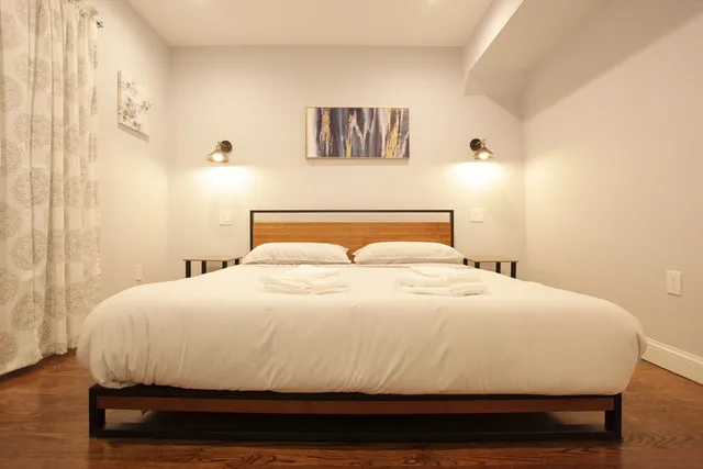 a bedroom with a bed and a wall painting