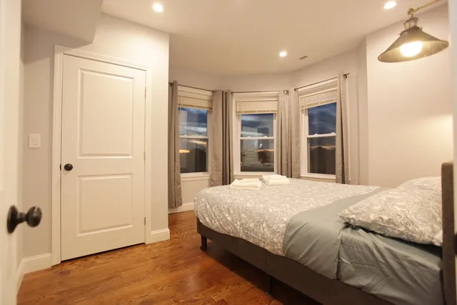 a bedroom with a bed and closet with wooden floor