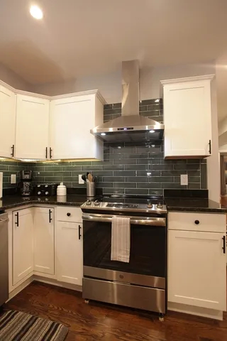 a kitchen with stainless steel appliances wooden cabinets and a stove top oven