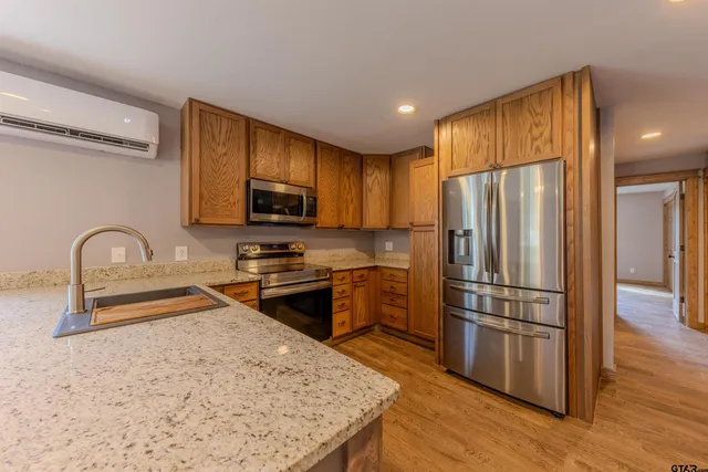 a kitchen with granite countertop a refrigerator and a sink