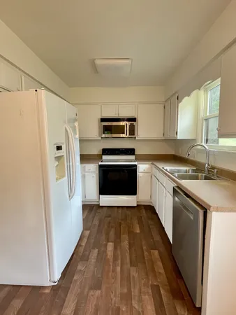 a kitchen with a sink a refrigerator a washer and dryer