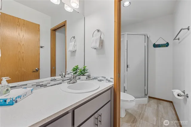 a bathroom with a sink and mirror with toilet