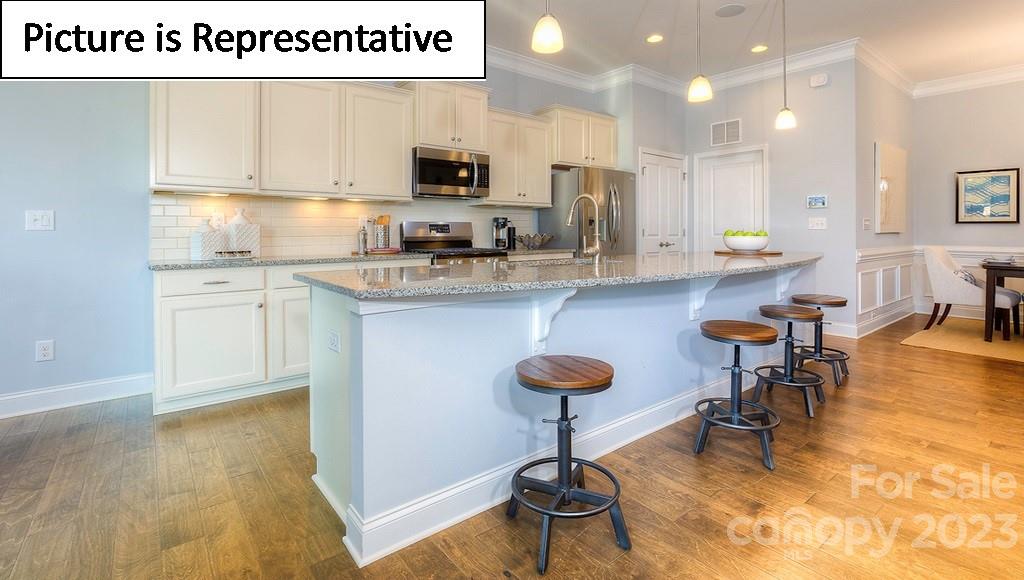 4190 Millstream Road Denver, NC 28037 - Photo 12 of 33 a kitchen with kitchen island granite countertop a sink a stove cabinets and a dining table