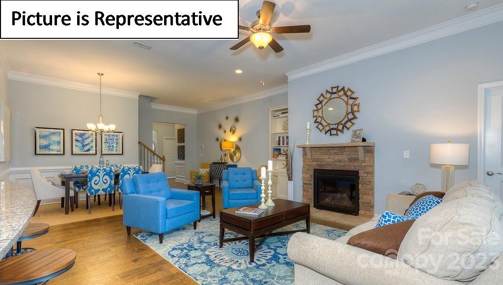 4190 Millstream Road Denver, NC 28037 - Photo 16 of 33 a living room with furniture a dining table and a fireplace