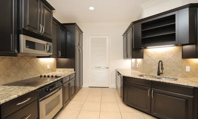 a kitchen with stainless steel appliances granite countertop a stove microwave and refrigerator