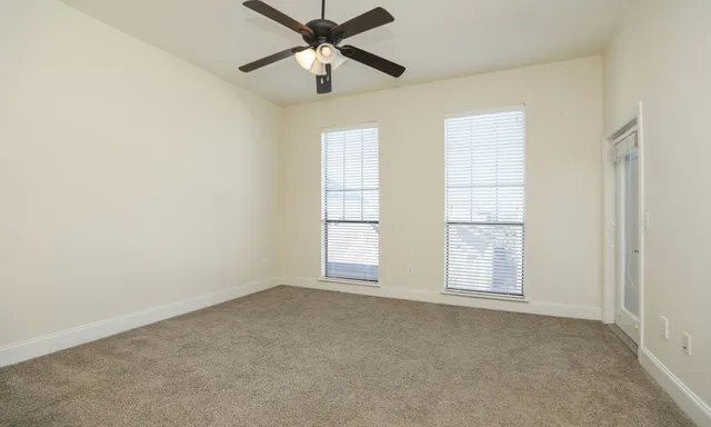 an empty room with chandelier fan