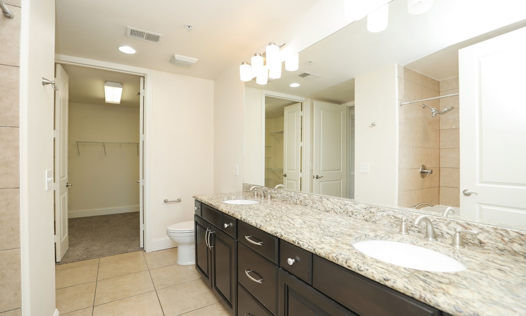 2120 Kipling Street, Unit 402 Houston, TX 77098 - Photo 23 of 30 a bathroom with a granite countertop sink a large mirror and a shower