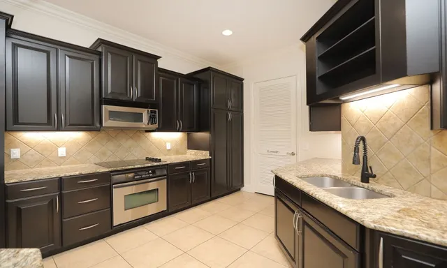 a kitchen with stainless steel appliances granite countertop wooden cabinets and a stove top oven
