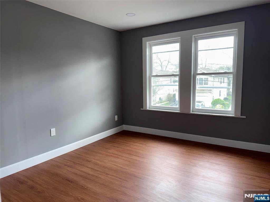 178 Berry Street Hackensack, NJ 07601 - Photo 10 of 22 an empty room with wooden floor and windows