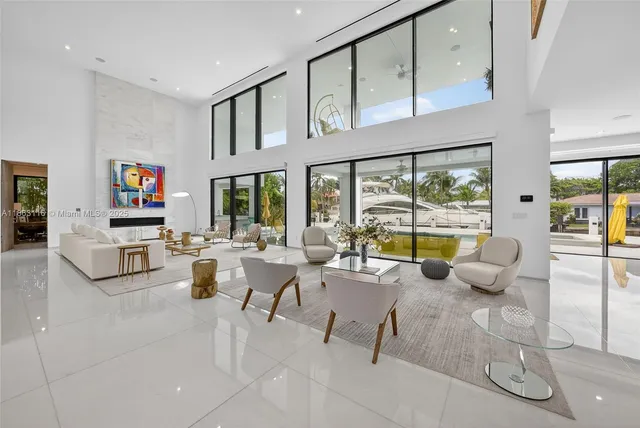 a large white kitchen with a large window and living room