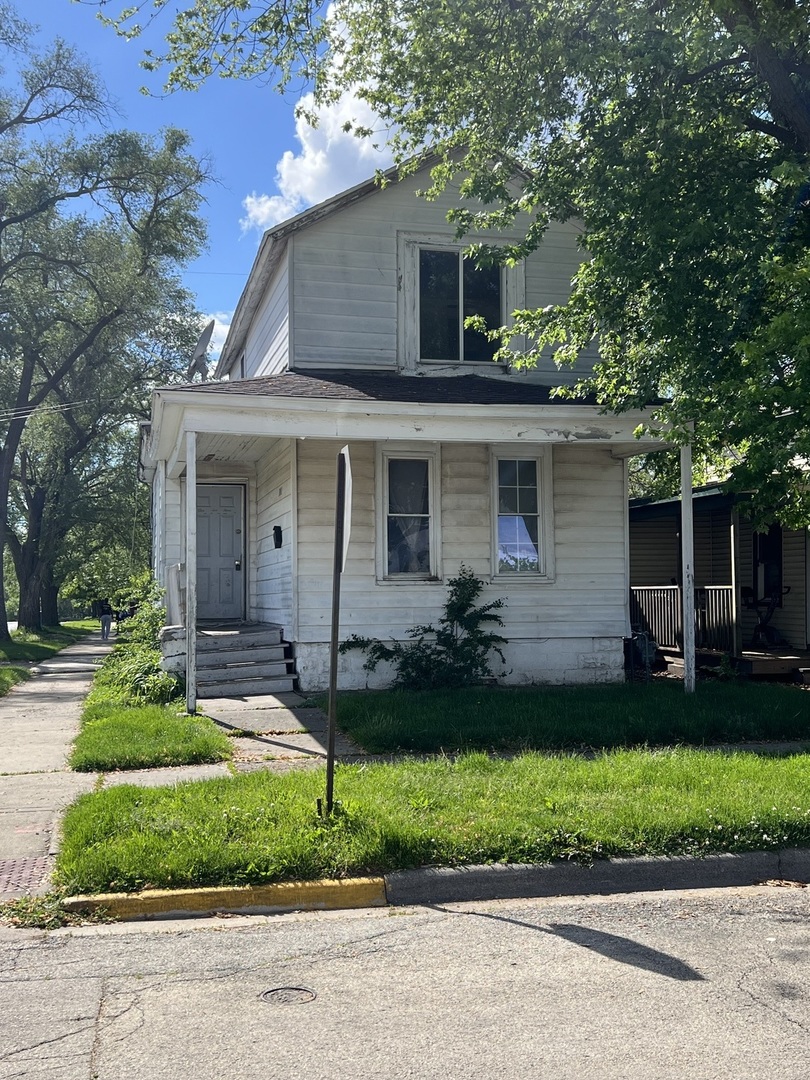 a front view of a house with a garden and plants