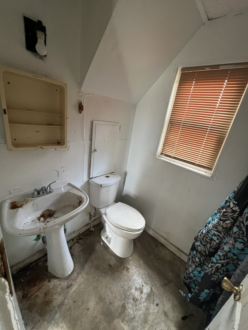 301 North West Avenue Kankakee, IL 60901 - Photo 5 of 13 a bathroom with a toilet sink and mirror