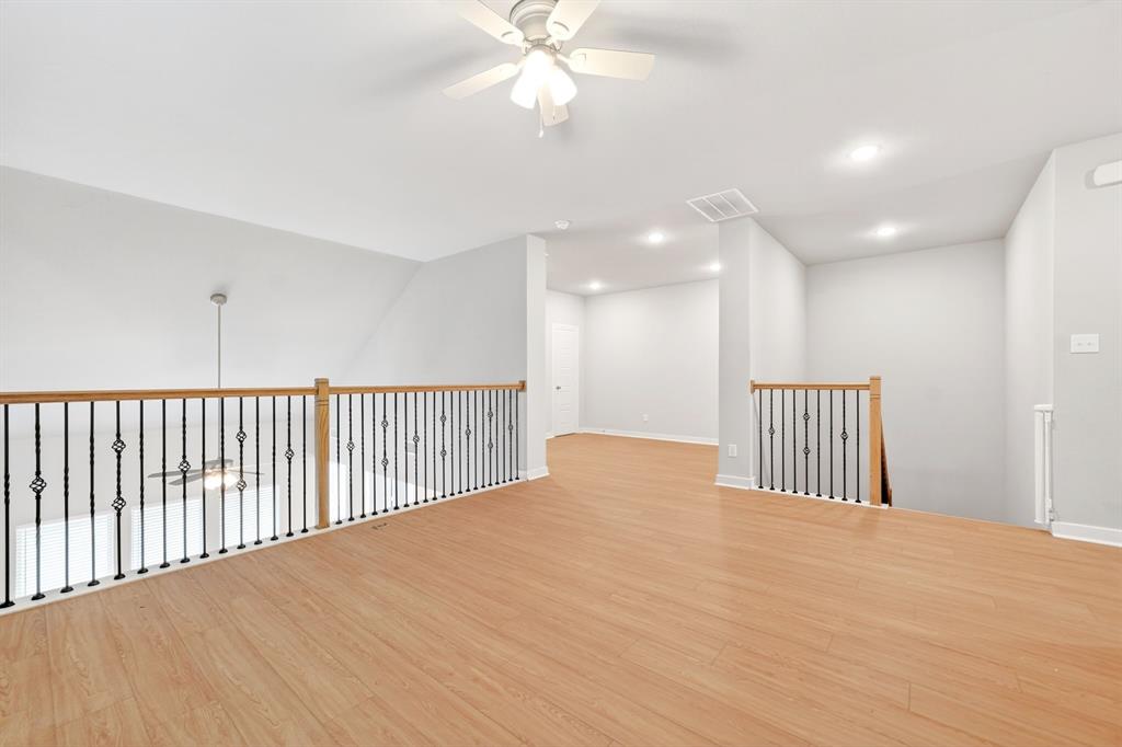 1810 Rhea Court Celina, TX 75009 - Photo 13 of 32 Open concept loft area featuring light wood flooring, light grey walls, and a white ceiling with a ceiling fan