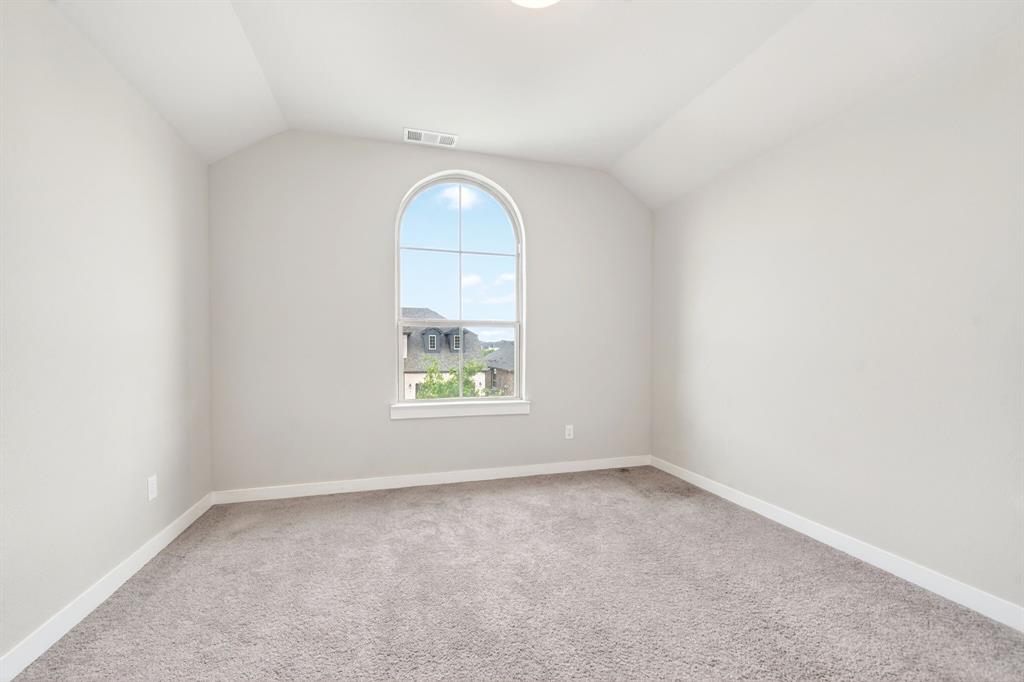 1810 Rhea Court Celina, TX 75009 - Photo 19 of 32 This room features an arched window with views of other properties, sloped ceilings, and light-colored carpet