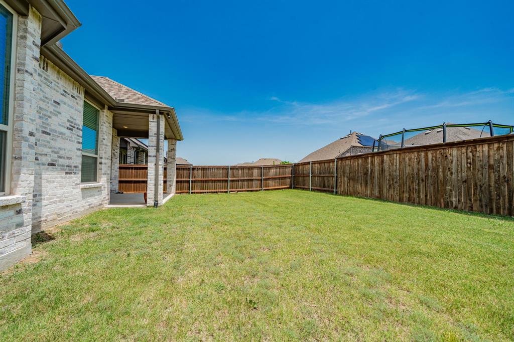 1810 Rhea Court Celina, TX 75009 - Photo 2 of 32 This property showcases a brick exterior with dark trim and shutters, featuring a prominent arched entry and an attached garage