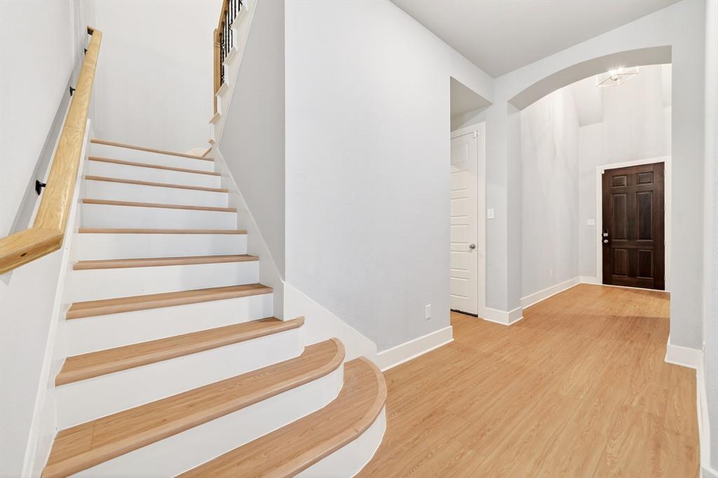 1810 Rhea Court Celina, TX 75009 - Photo 25 of 32 Entryway featuring a wooden staircase with white risers, a light wood handrail, and light wood flooring