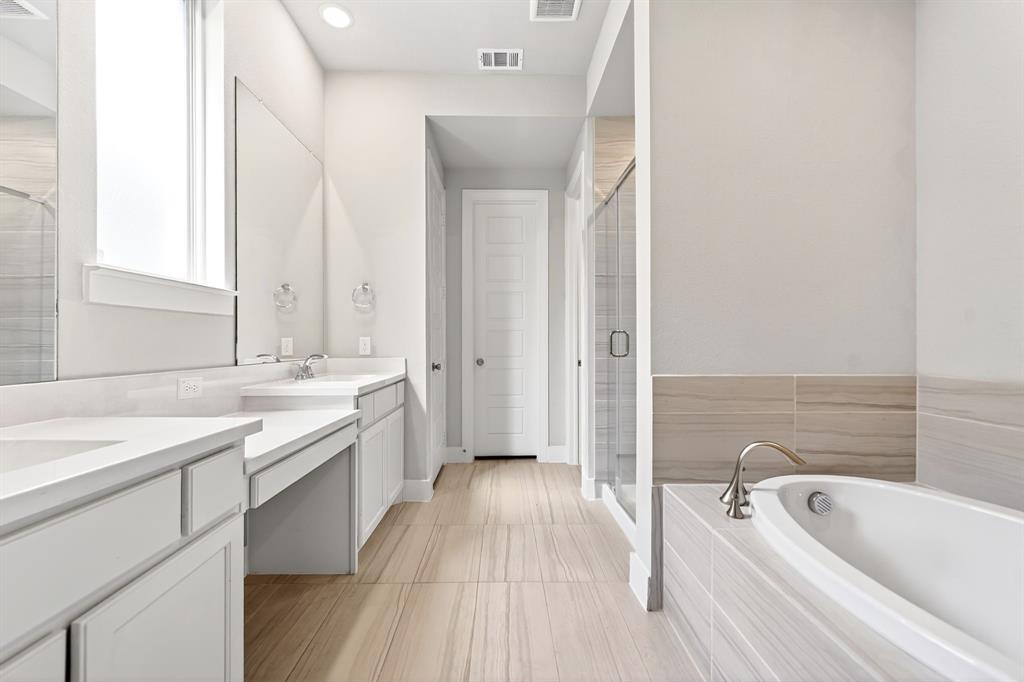1810 Rhea Court Celina, TX 75009 - Photo 9 of 32 The bathroom features a double vanity with ample counter space, a built-in bathtub, and a glass-enclosed shower