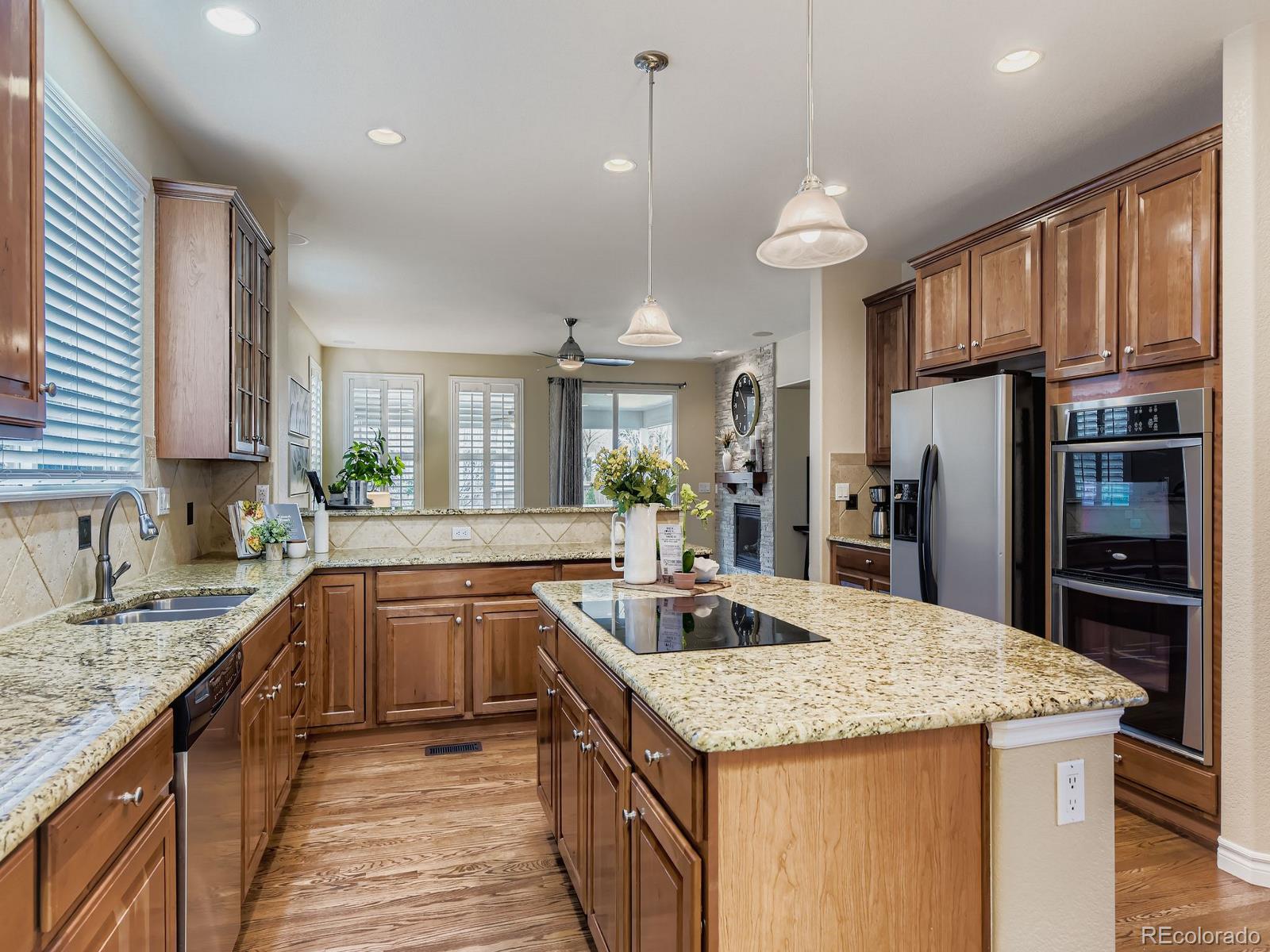 11074 Grayledge Circle Highlands Ranch, CO 80130 - Photo 15 of 47 a kitchen with granite countertop kitchen island a sink appliances and cabinets
