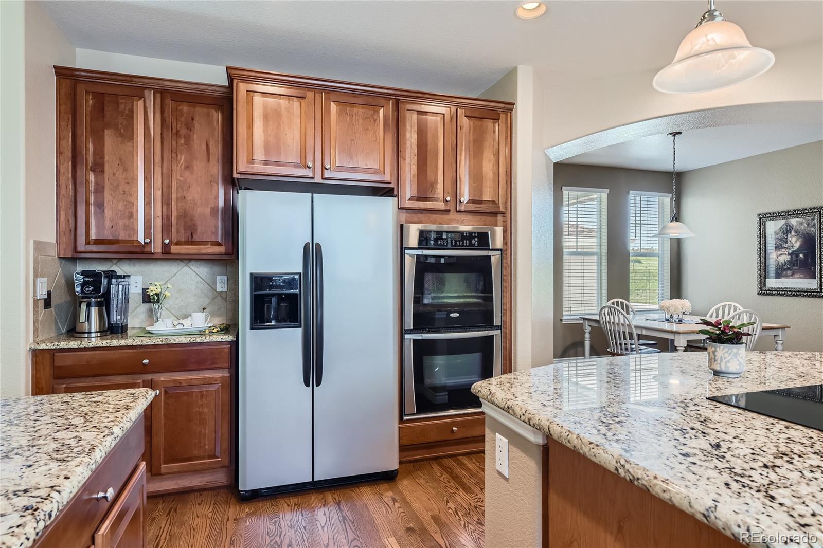11074 Grayledge Circle Highlands Ranch, CO 80130 - Photo 17 of 47 a kitchen with stainless steel appliances granite countertop a refrigerator and a stove top oven