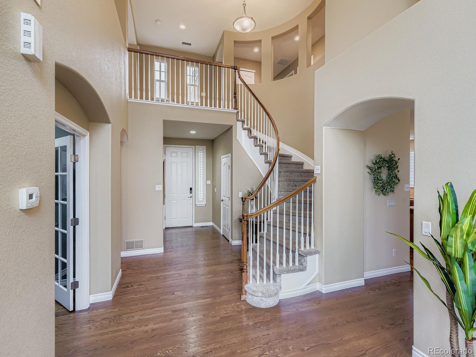 11074 Grayledge Circle Highlands Ranch, CO 80130 - Photo 3 of 47 a view of entryway and hall with wooden floor